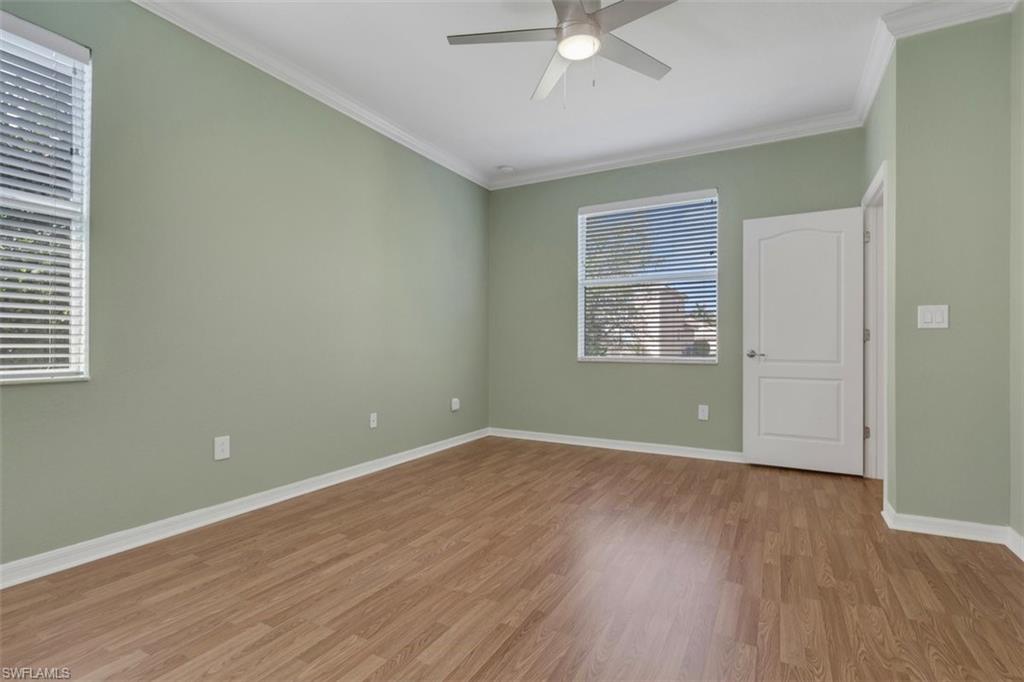 Spare room with crown molding, a ceiling fan, and wood finished floors