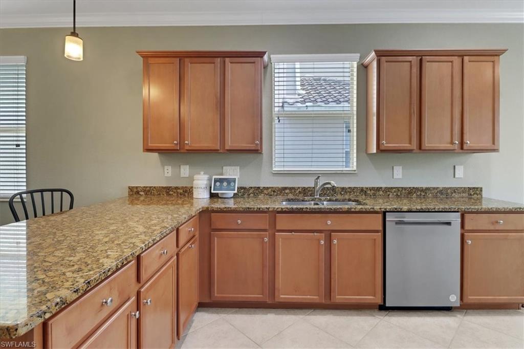 Kitchen with brown cabinets, a sink, a peninsula, ornamental molding, and dishwasher
