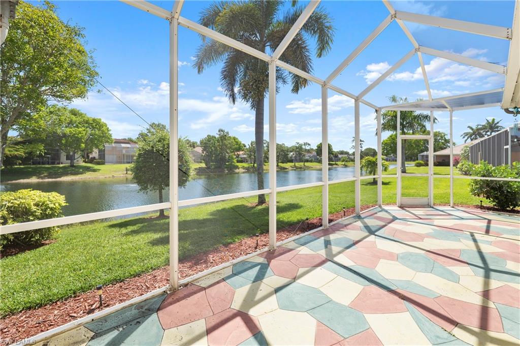 Screened patio featuring a colorful geometric paver floor overlooking a water feature and established landscaping