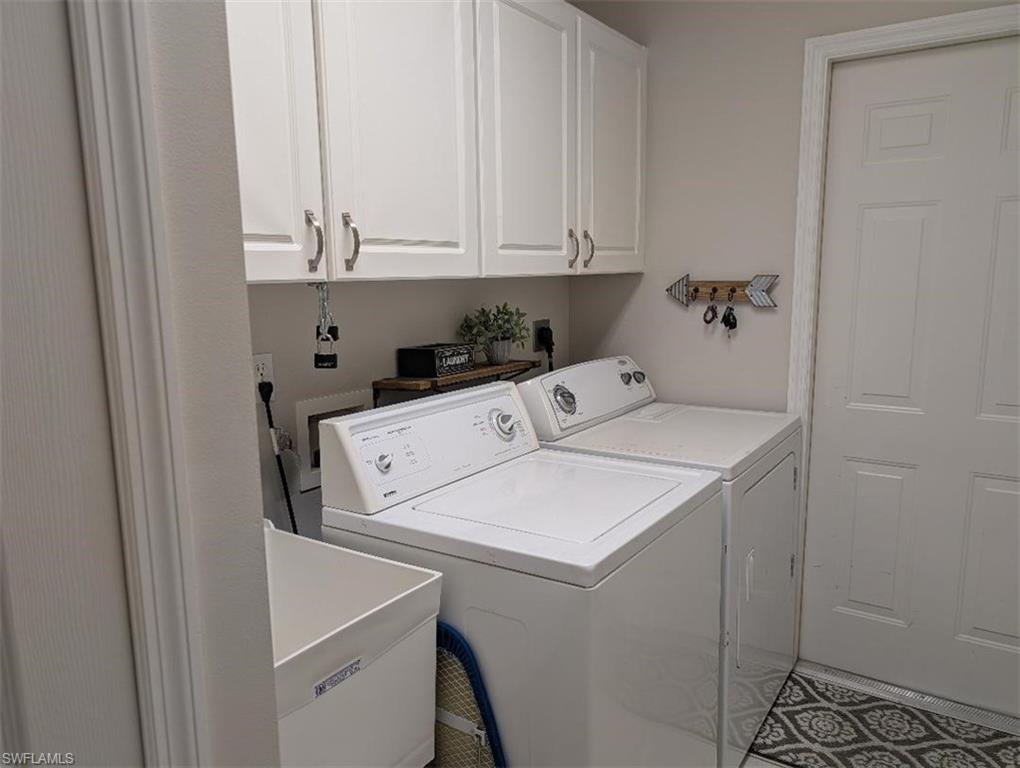 Laundry area featuring independent washer and dryer and cabinet space
