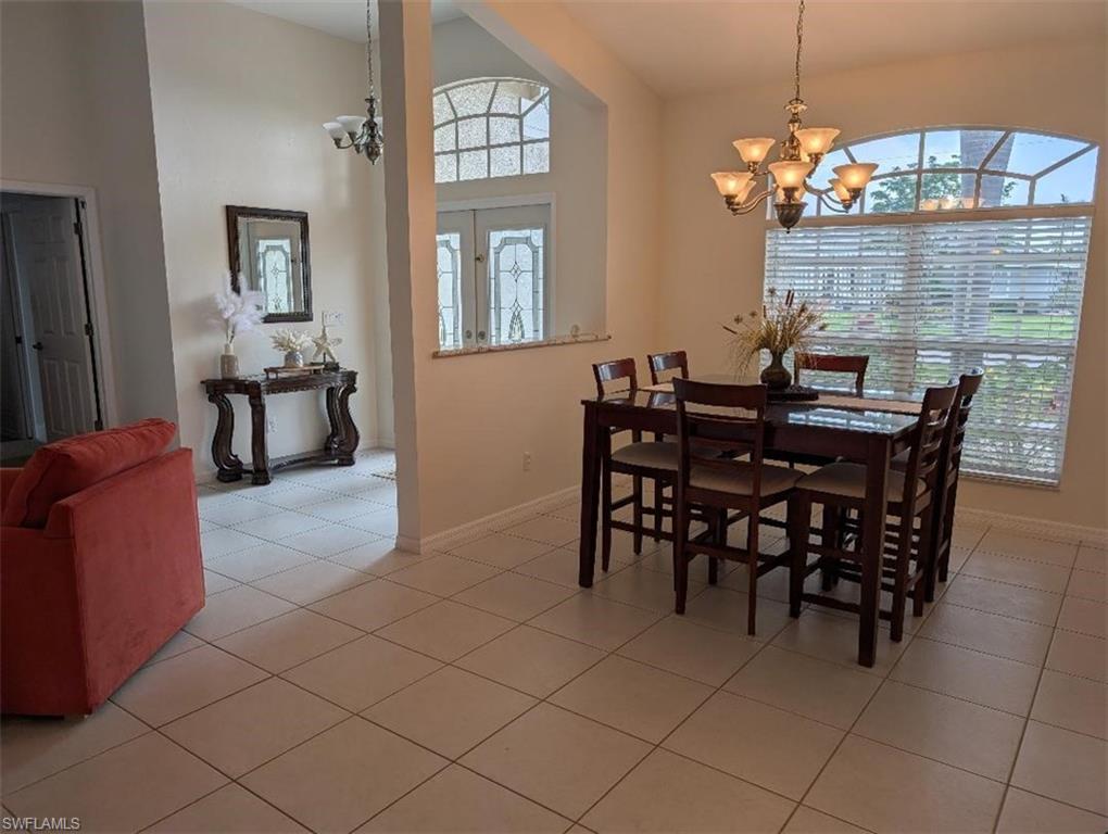 Dining room featuring a chandelier, baseboards, and light tile patterned floors