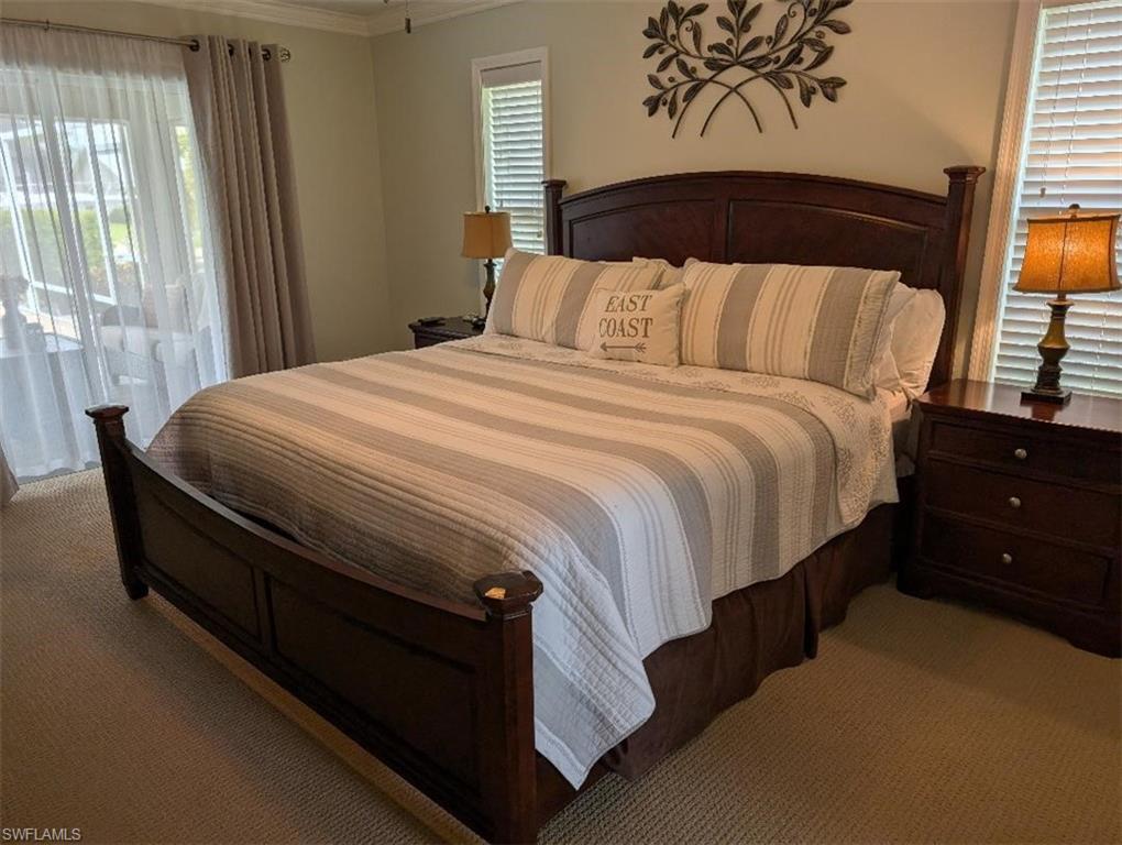 Bedroom featuring carpet, crown molding, multiple windows, and access to exterior