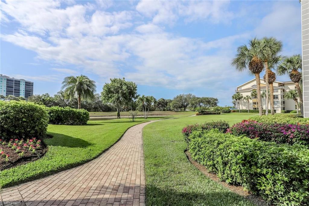 Paver pathway surrounded by lush landscaping and expansive green space