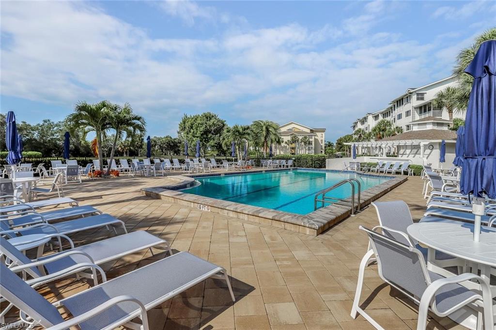 Expansive community swimming pool surrounded by a large paver deck