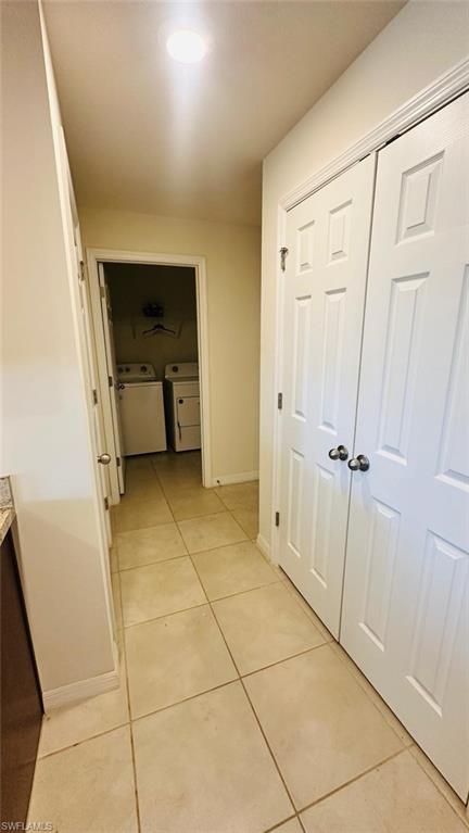 Dedicated laundry area featuring a washer and dryer, recessed lighting, and neutral tile flooring