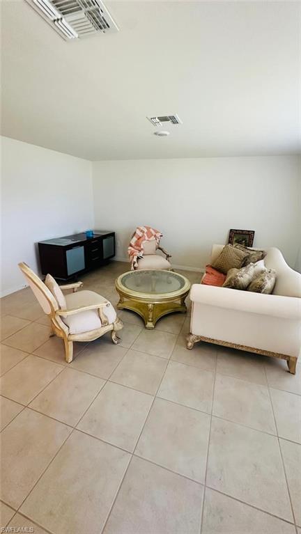 Spacious room featuring neutral-toned tile flooring and white walls