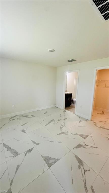 Spacious room featuring large format tile flooring with a marble-effect pattern, recessed lighting, and a white ceiling