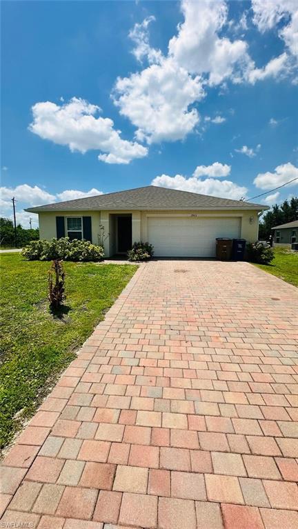 Paver driveway leading to a single-story residence with a two-car garage