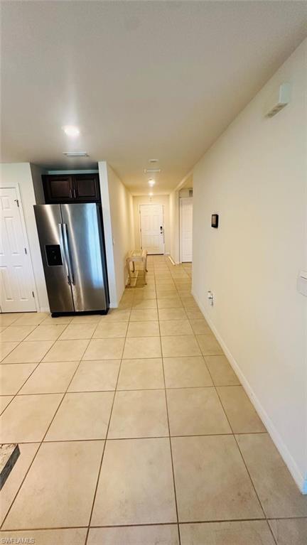 Cream-colored tile flooring extending through the hallway and kitchen area