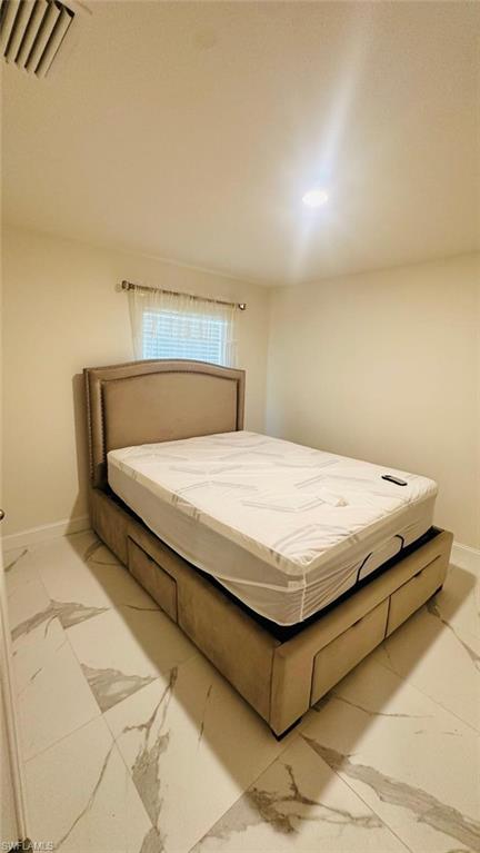 Bright room featuring white walls and a single window with blinds