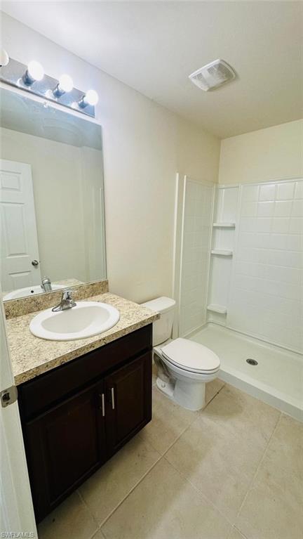 Bathroom featuring a dark wood-finish vanity with a light speckled countertop, under-mount sink, and chrome faucet