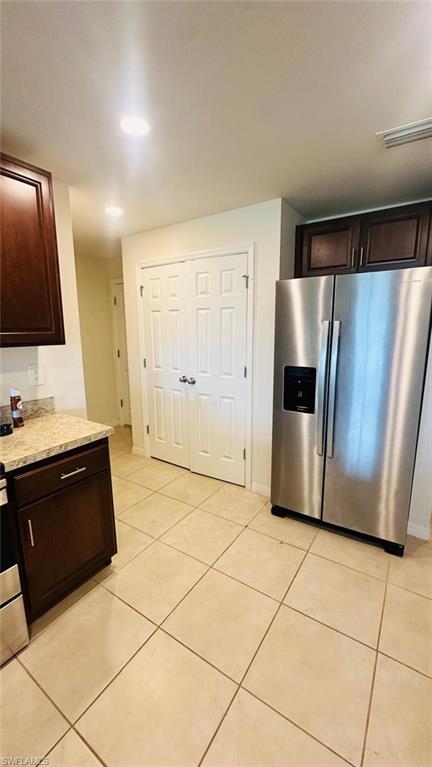 Kitchen featuring stainless steel appliances, dark wood cabinetry, and a granite-look countertop