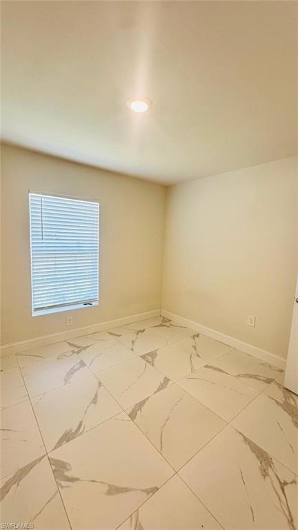 Room featuring large format porcelain tile flooring with grey veining, light neutral wall paint, and recessed ceiling lighting