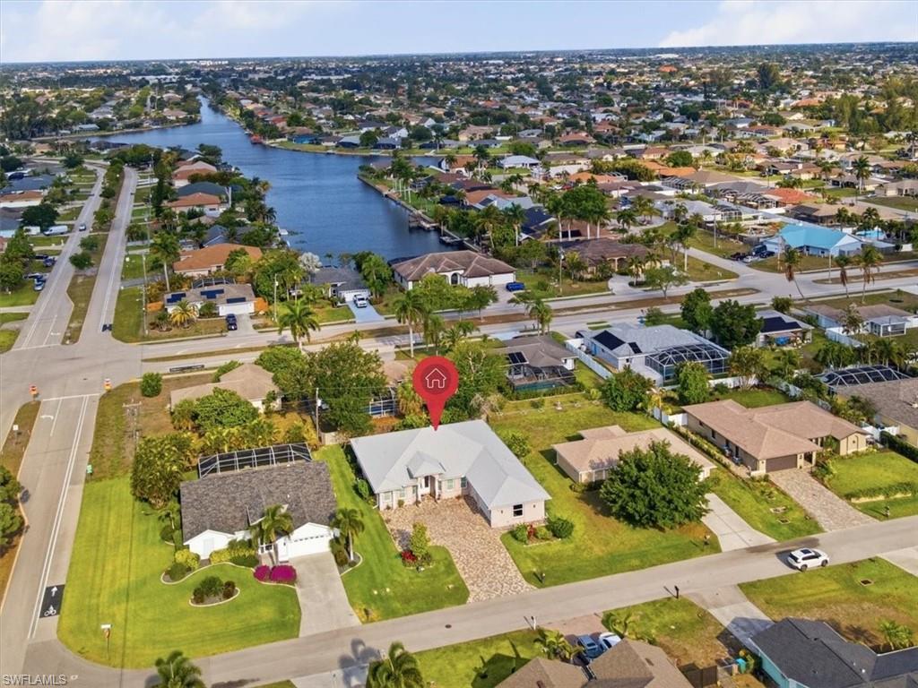 Aerial perspective showcasing a canal-front community with a prominent single-story residence