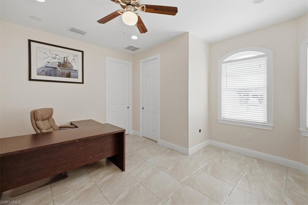 Spacious room featuring neutral-toned walls and large format tile flooring