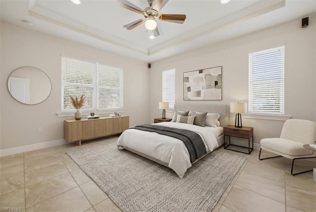 Spacious room featuring a tray ceiling with a ceiling fan, recessed lighting, and tile flooring