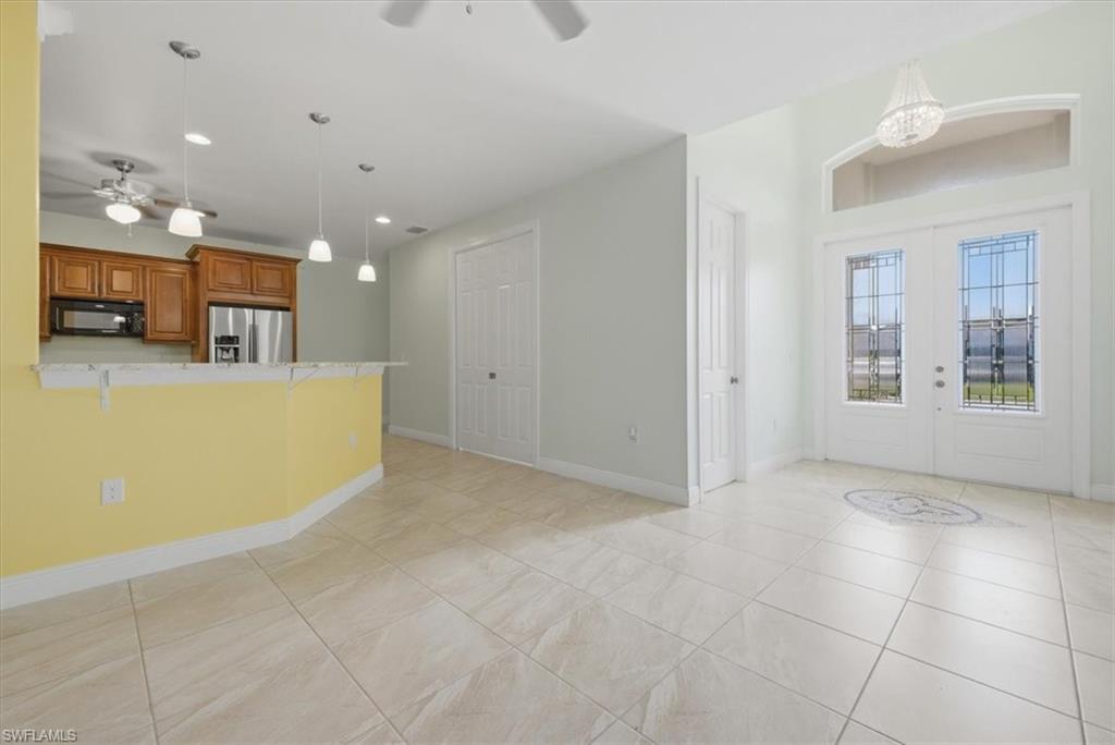 Open-concept living area with large format tile flooring and a dual front entry door