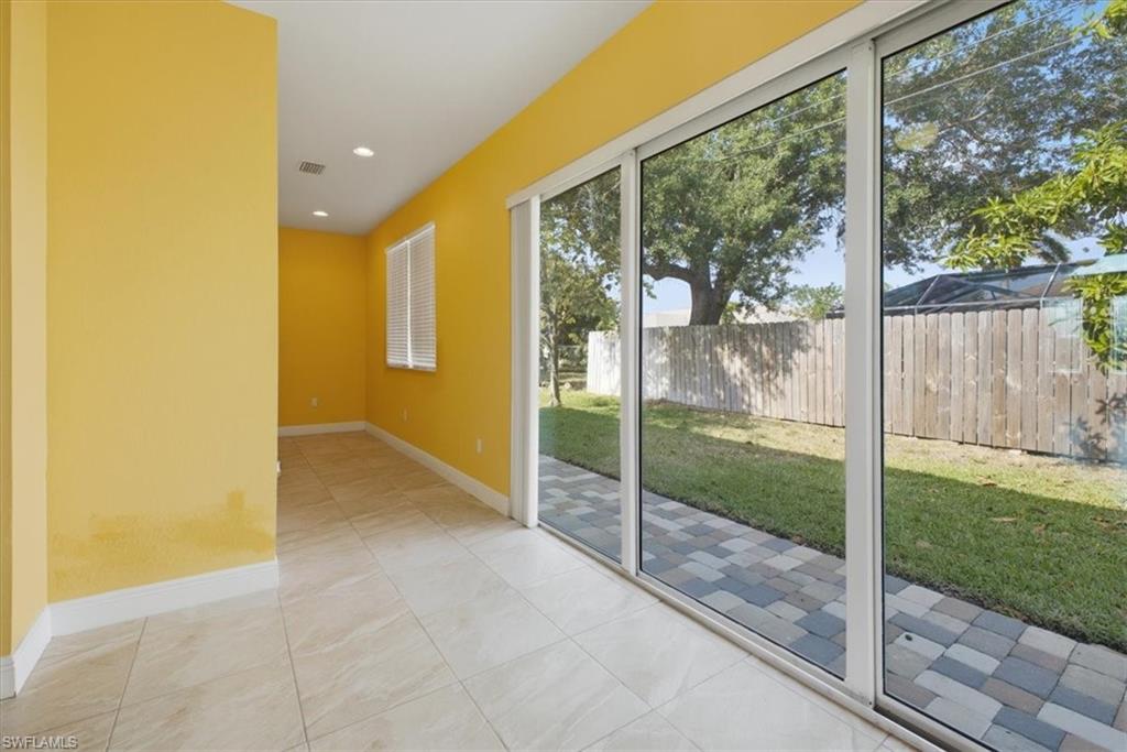 Spacious interior featuring large sliding glass doors opening to a paved patio