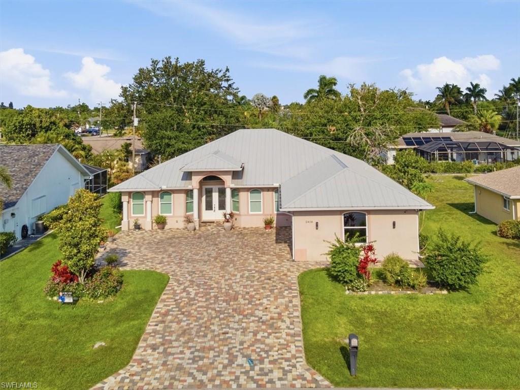 Contemporary residence with a metal roof and an arched double-door entry