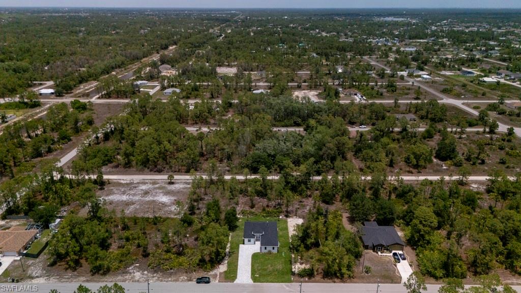 Aerial perspective showcasing multiple land parcels and residential structures within a developing area