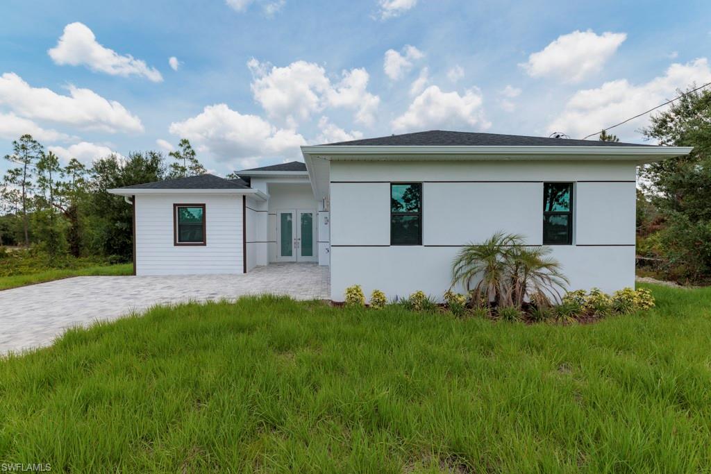 Contemporary single-story residence featuring white siding and a dark shingle roof
