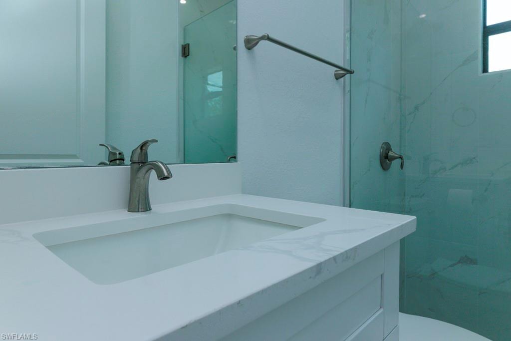 Vanity featuring an integrated sink, brushed nickel faucet, and a light-toned countertop with subtle veining