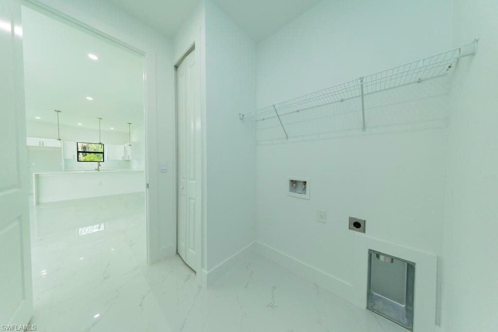 Dedicated laundry space featuring white walls and tile flooring