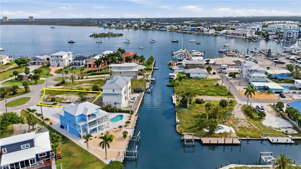 Expansive waterfront lot with clear boundaries, offering immediate canal access, potential for a private dock, and an existing concrete patio - Virtually Edited Image