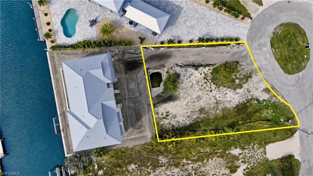 Aerial view of lot surrounded by bay- virtually enhanced