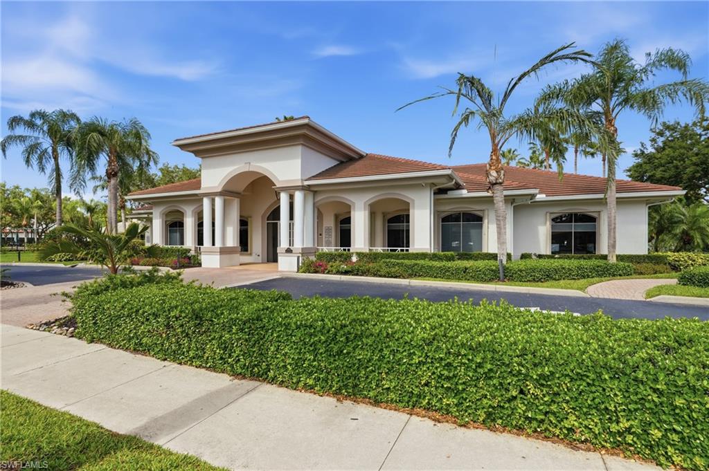 Stucco exterior with an arched portico, column accents, and a tile roof