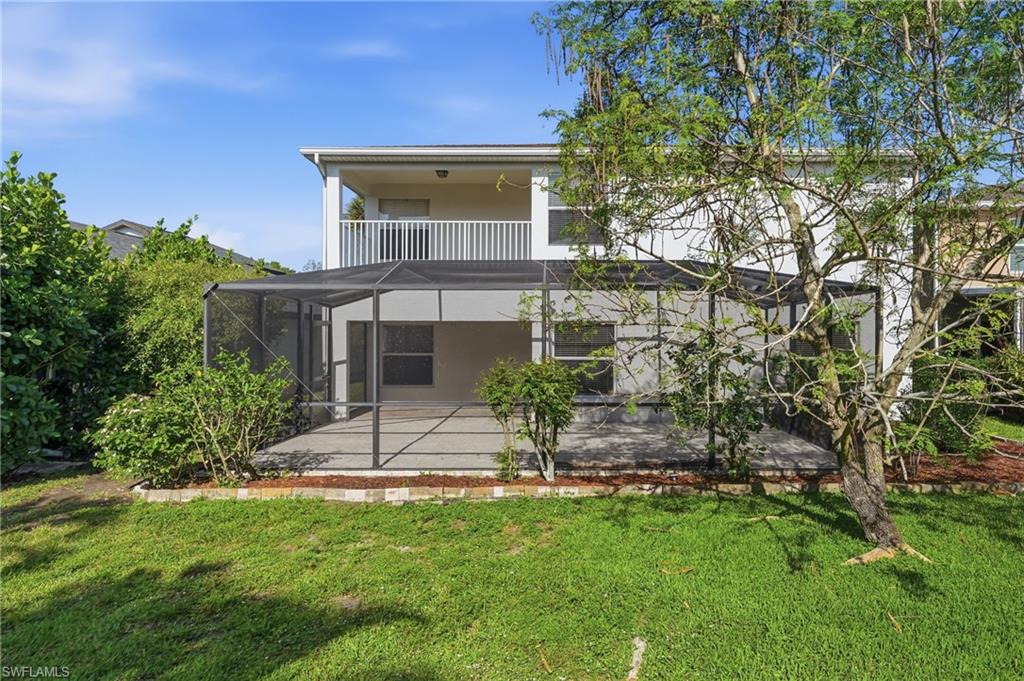 Screened patio with a concrete slab, surrounded by mature landscaping and a grassy yard