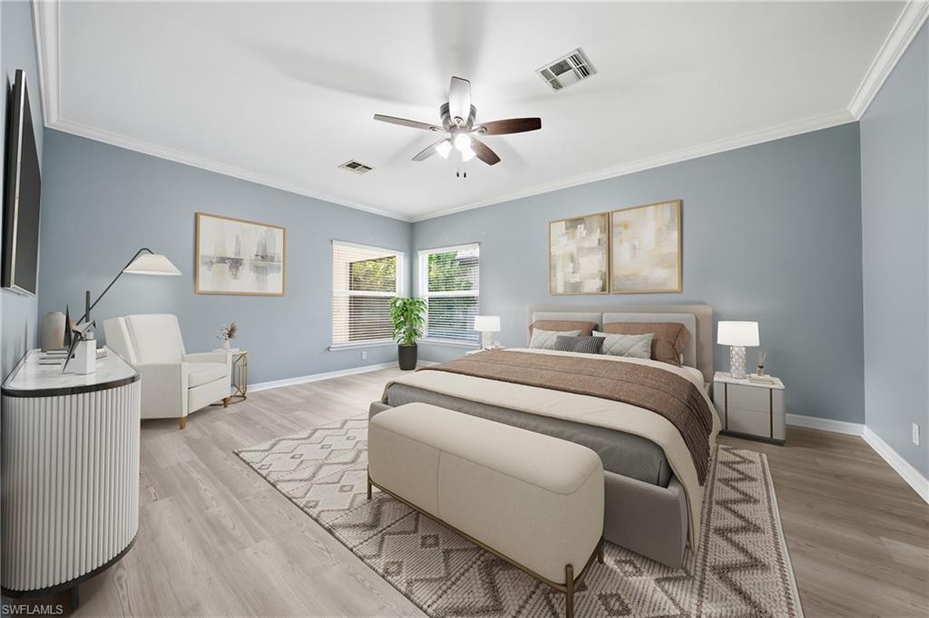 Spacious room with light wood-finish flooring, multiple windows, crown molding, and a ceiling fan with integrated lighting