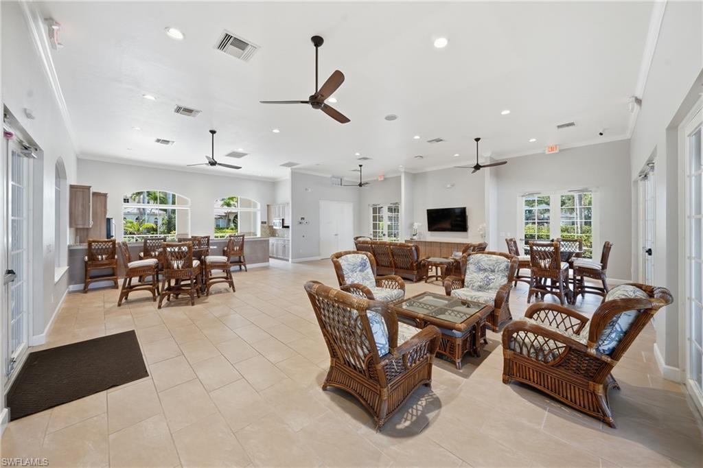 Spacious common area featuring light-toned tile flooring, multiple ceiling fans, and recessed lighting