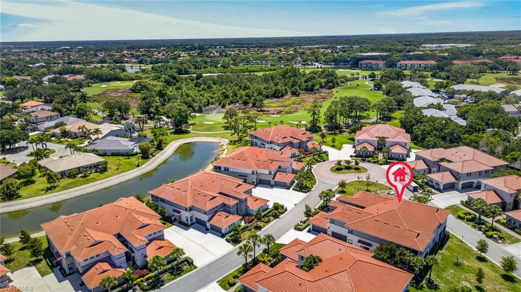 Aerial perspective showcasing the community's red tile roofs, verdant landscaping, and a central roundabout