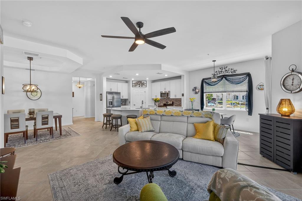 Open-concept living space featuring neutral tile flooring, a contemporary ceiling fan, and recessed lighting