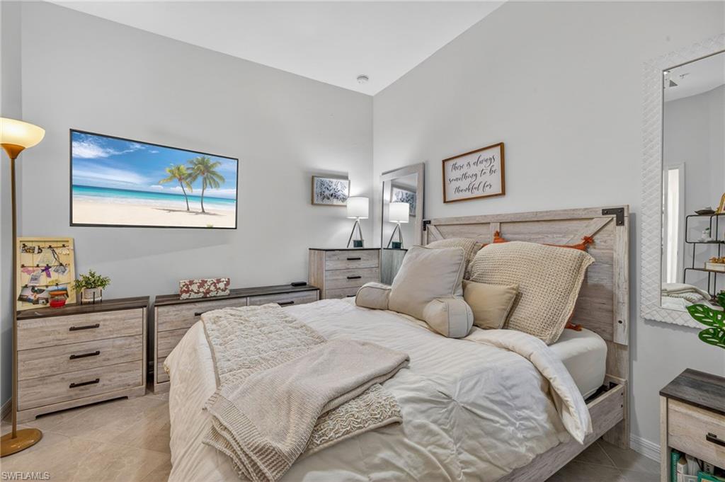 Bedroom featuring light gray wall paint, a tray ceiling, and tile flooring