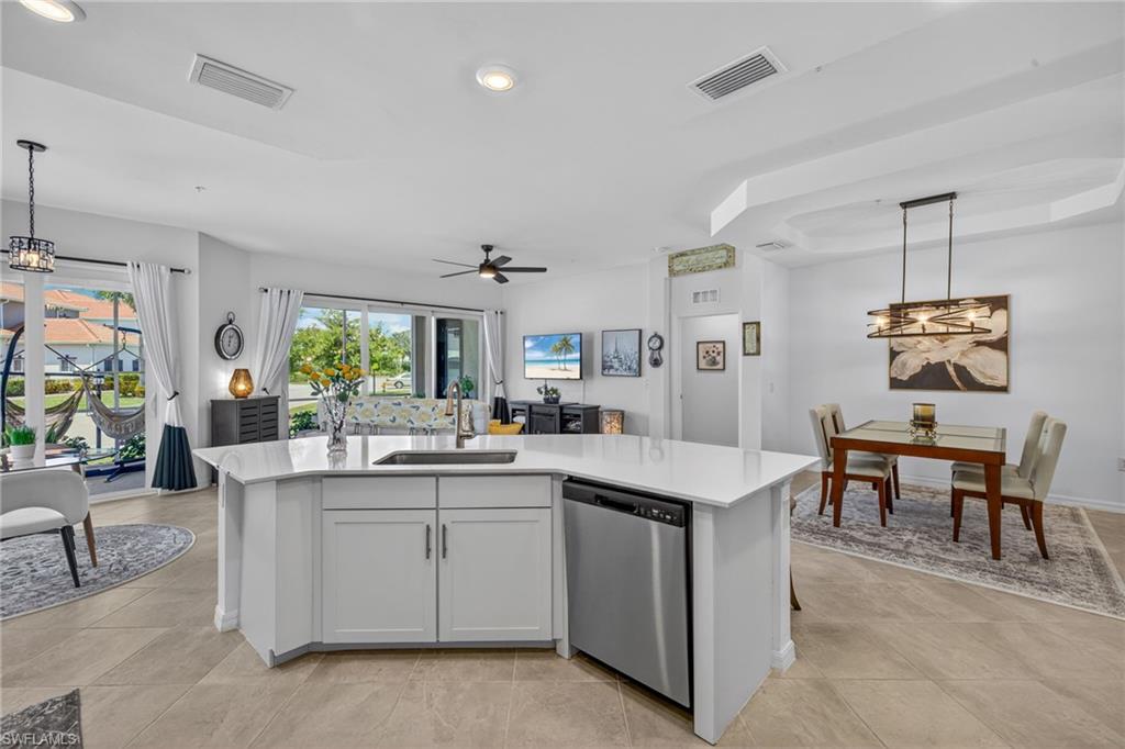 Kitchen island featuring white cabinetry, a stainless steel dishwasher, and a rectangular undermount sink