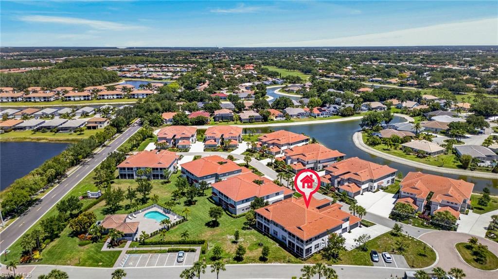 Aerial capturing a residential community featuring multiple buildings with red tile roofs
