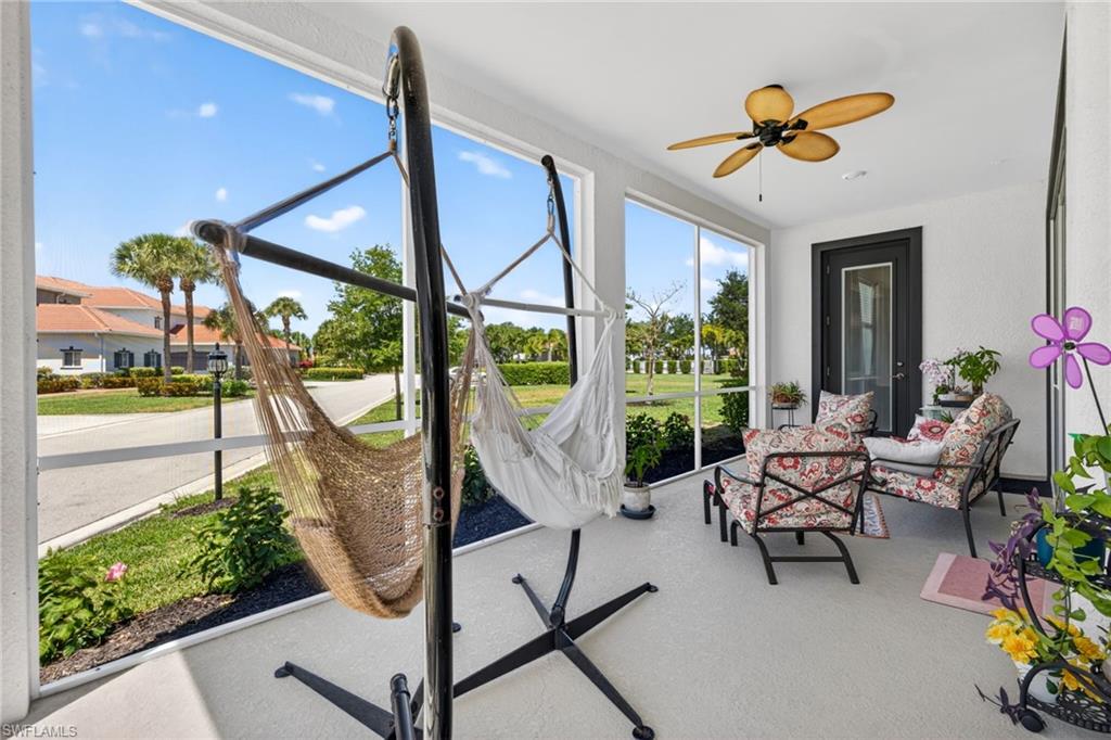 Screened lanai featuring an outdoor ceiling fan, light-colored flooring, and a dark-framed exterior door with clear glass panels