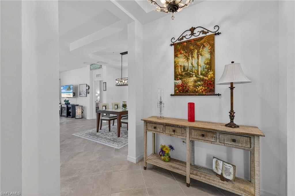 Entryway featuring tile flooring, a decorative console table, and a tiered ceiling detail