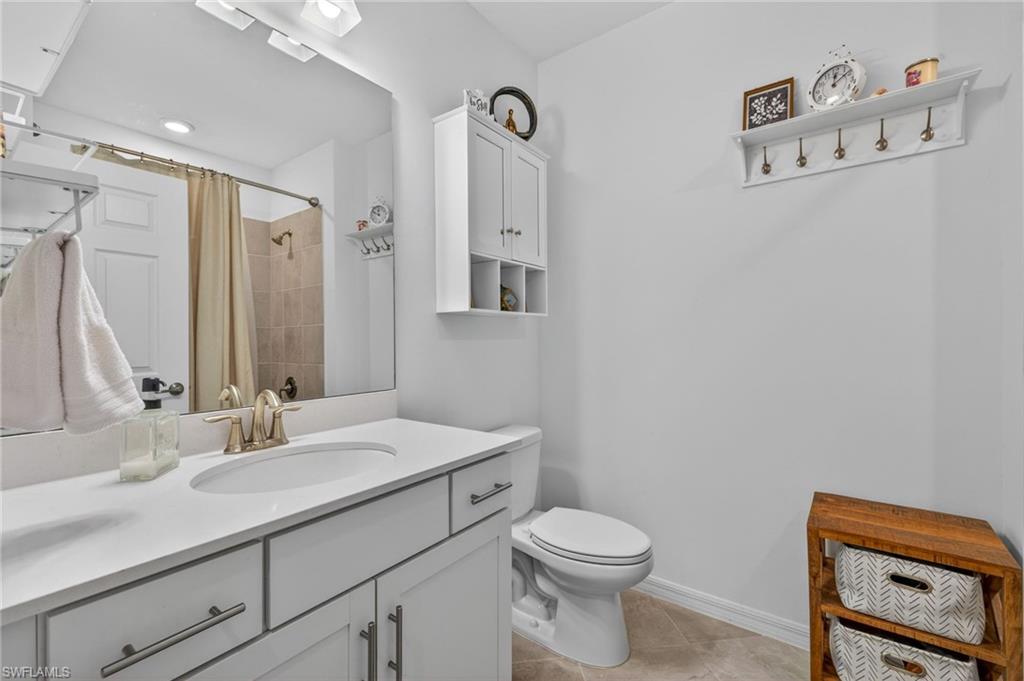 Bathroom featuring a single vanity with an integrated sink, brushed nickel faucet, and white countertop