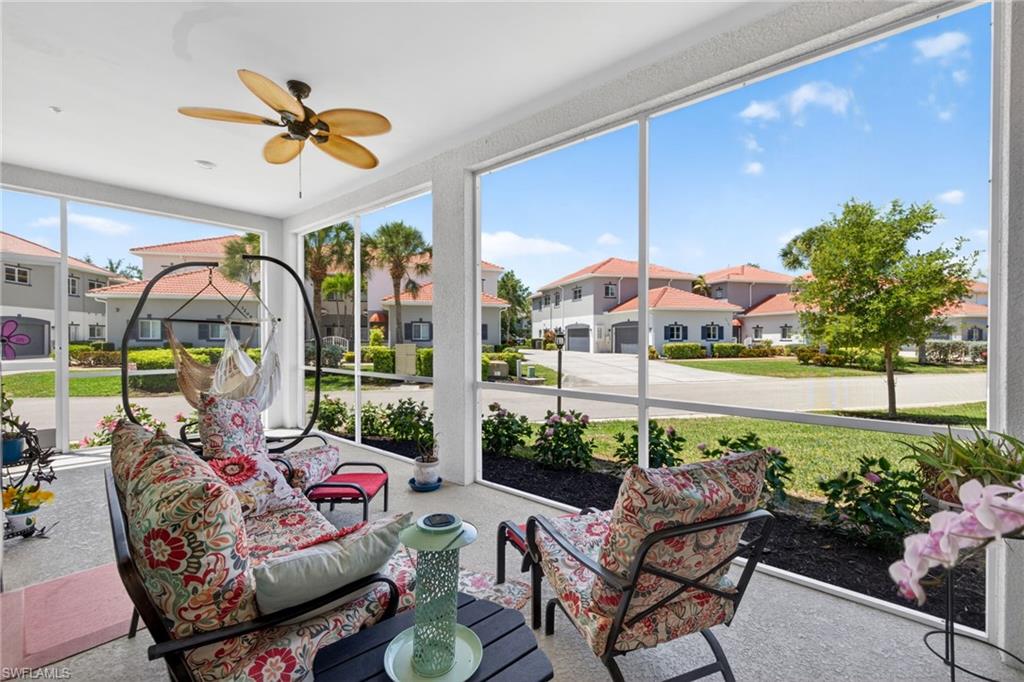 Screened lanai featuring a ceiling fan, concrete flooring, and surrounding landscaping