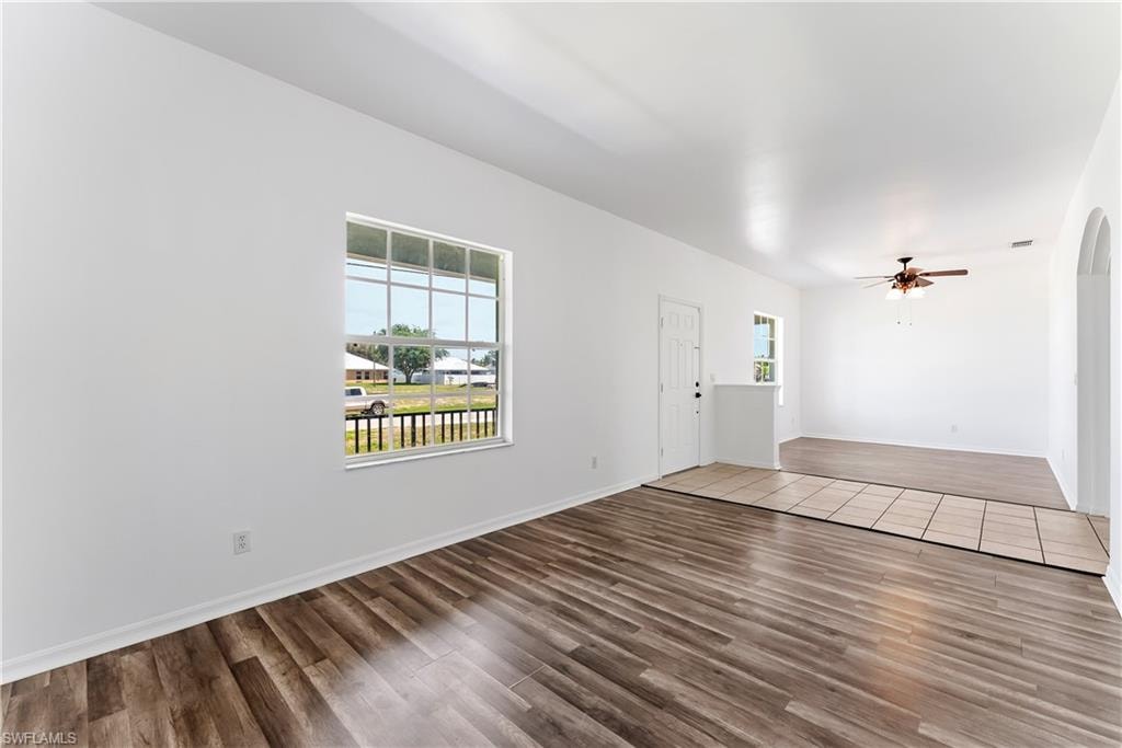 Open concept interior featuring wood-finish flooring, white walls, and a multi-pane window