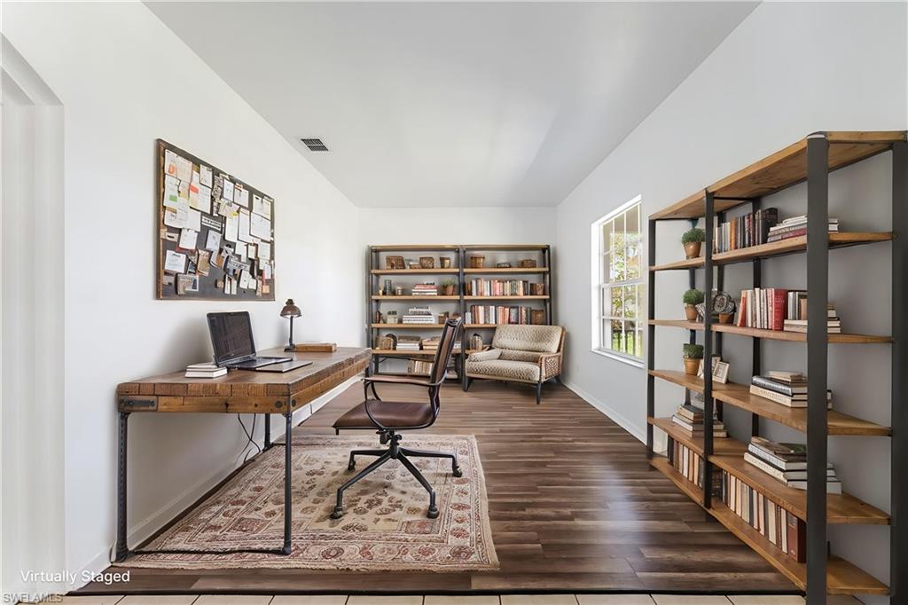 STAGED Spacious interior room featuring wood-finish flooring and light-toned walls