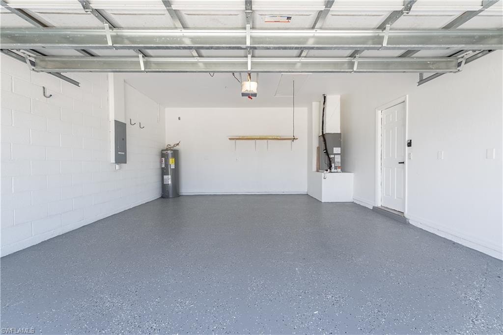 Spacious garage featuring a durable speckled epoxy floor, white painted block walls, and an accessible side entrance