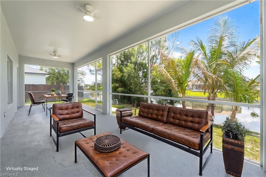 STAGED Screened patio featuring a solid ceiling with two flush-mount ceiling fans, concrete flooring, and distant water views