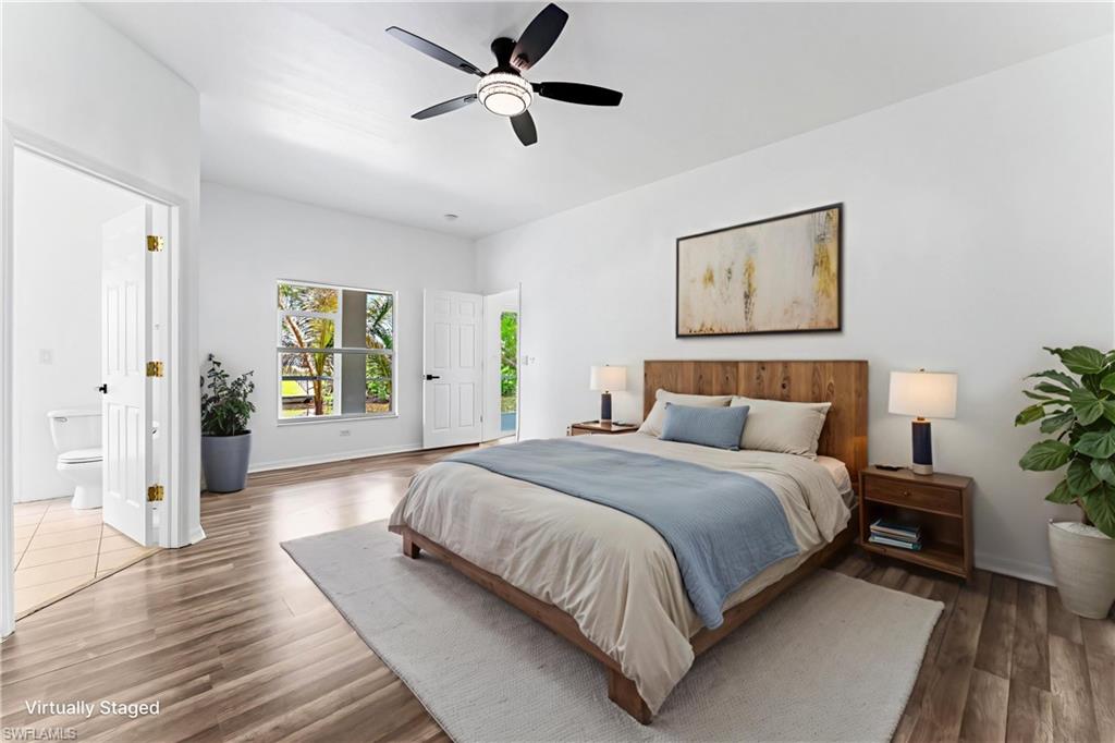 STAGED Spacious room featuring wood-finish flooring, a contemporary ceiling fan, and a large window