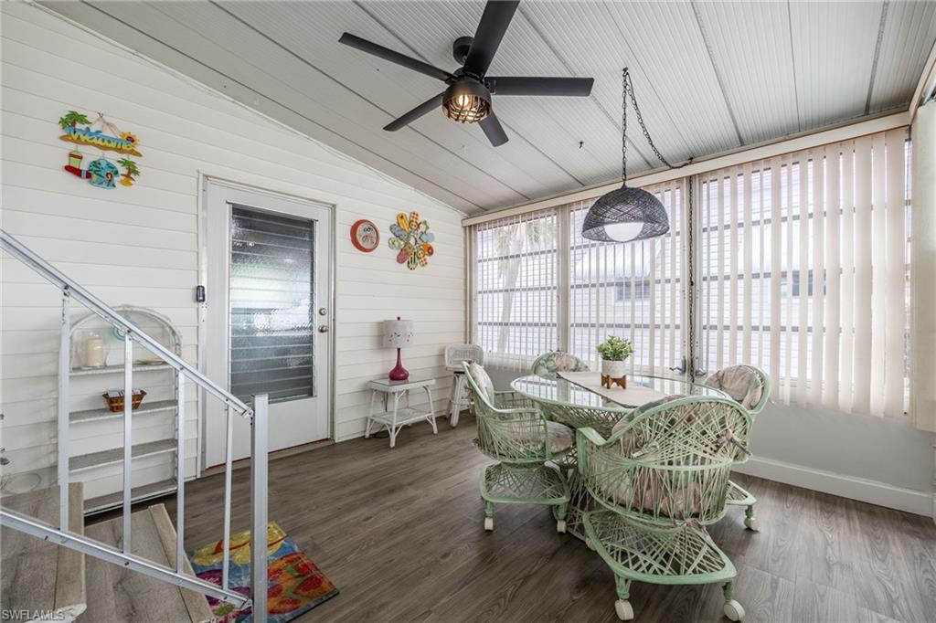 New flooring, new fan, surround glass windows and screens. Great extra space - this is your lanai/Florida Room! Access from home and car port and leads to the huge workroom/laundry space.