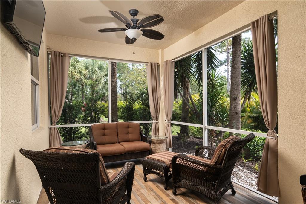 Screened lanai featuring wood-finish tile flooring and a ceiling fan