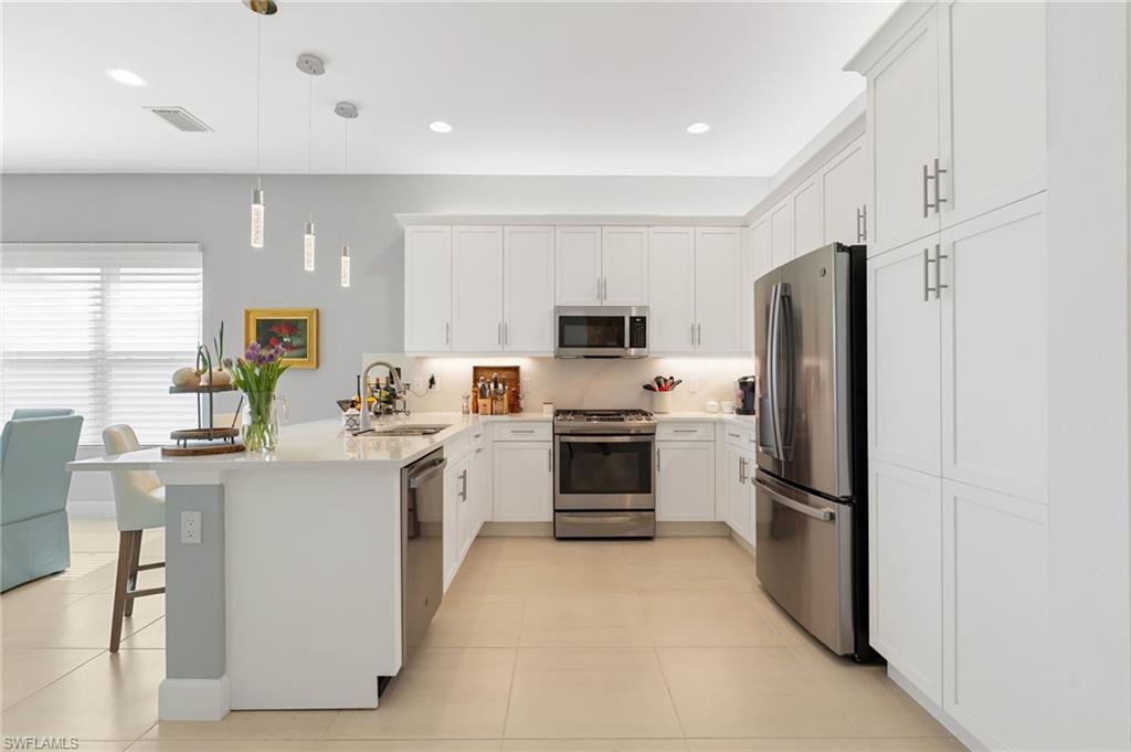 White and bright kitchen features designer lighting